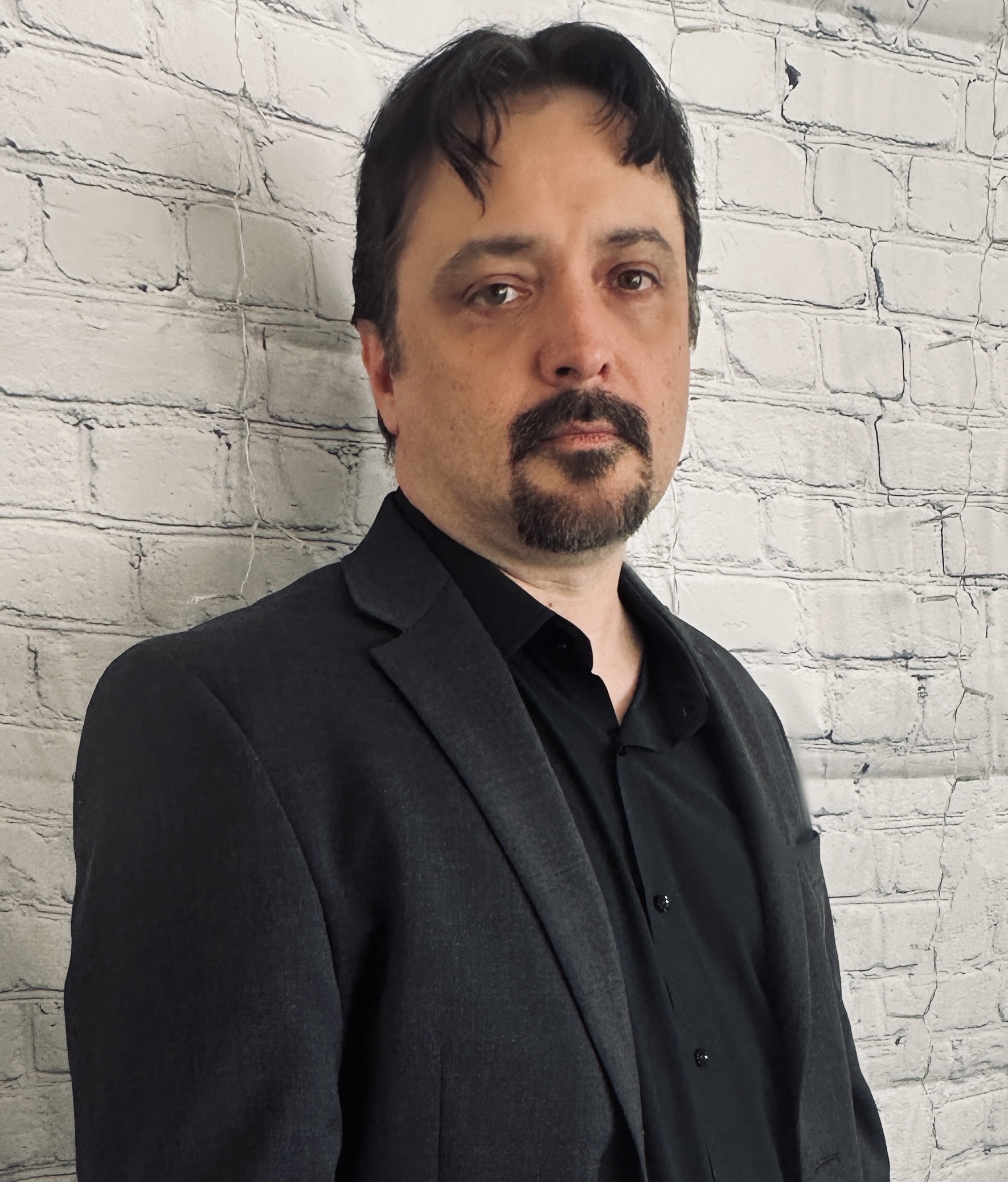 Rickie Lee Tanner serious headshot in a black shirt